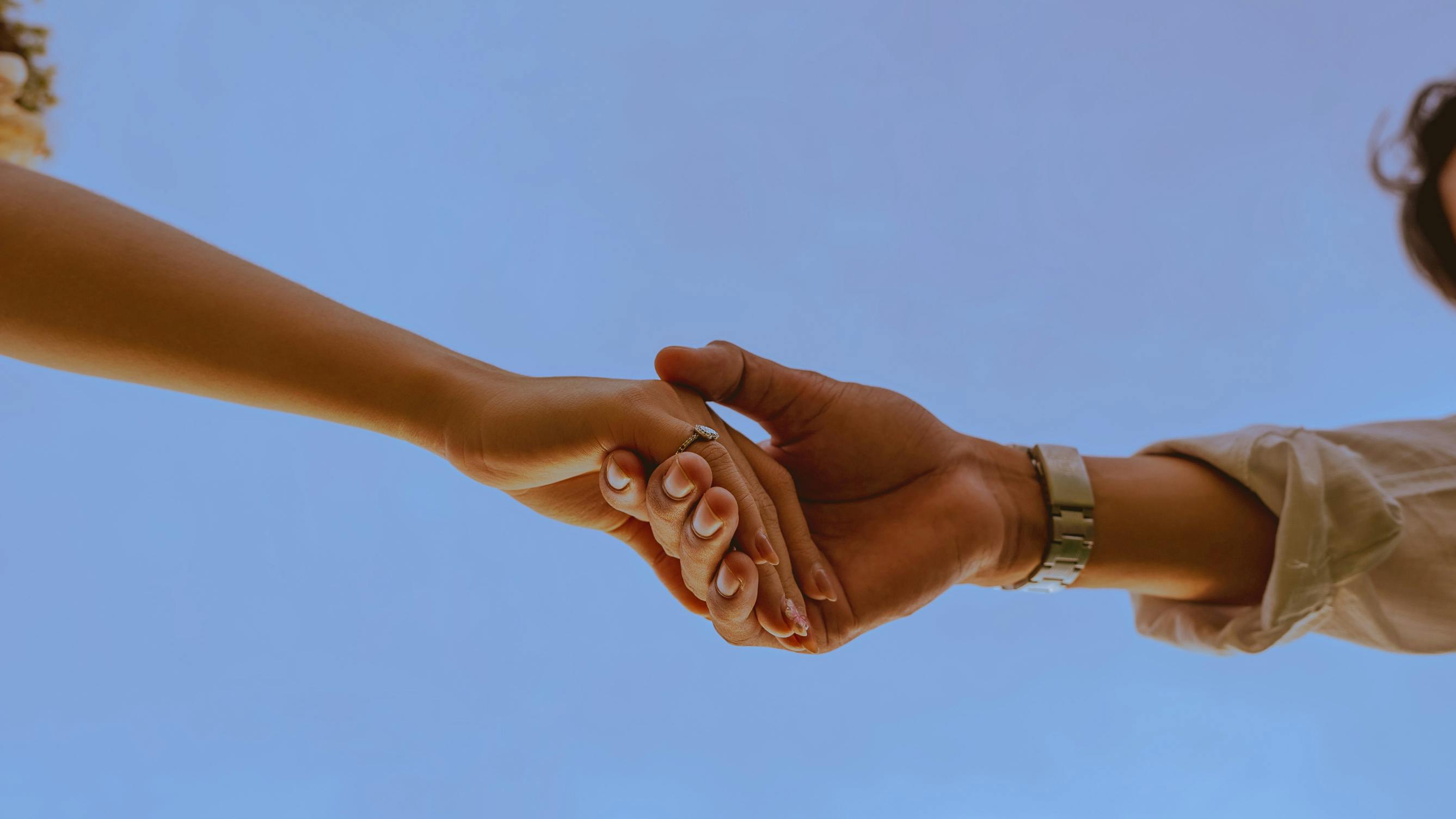 deux personnes se tenant les mains en signe de soutien